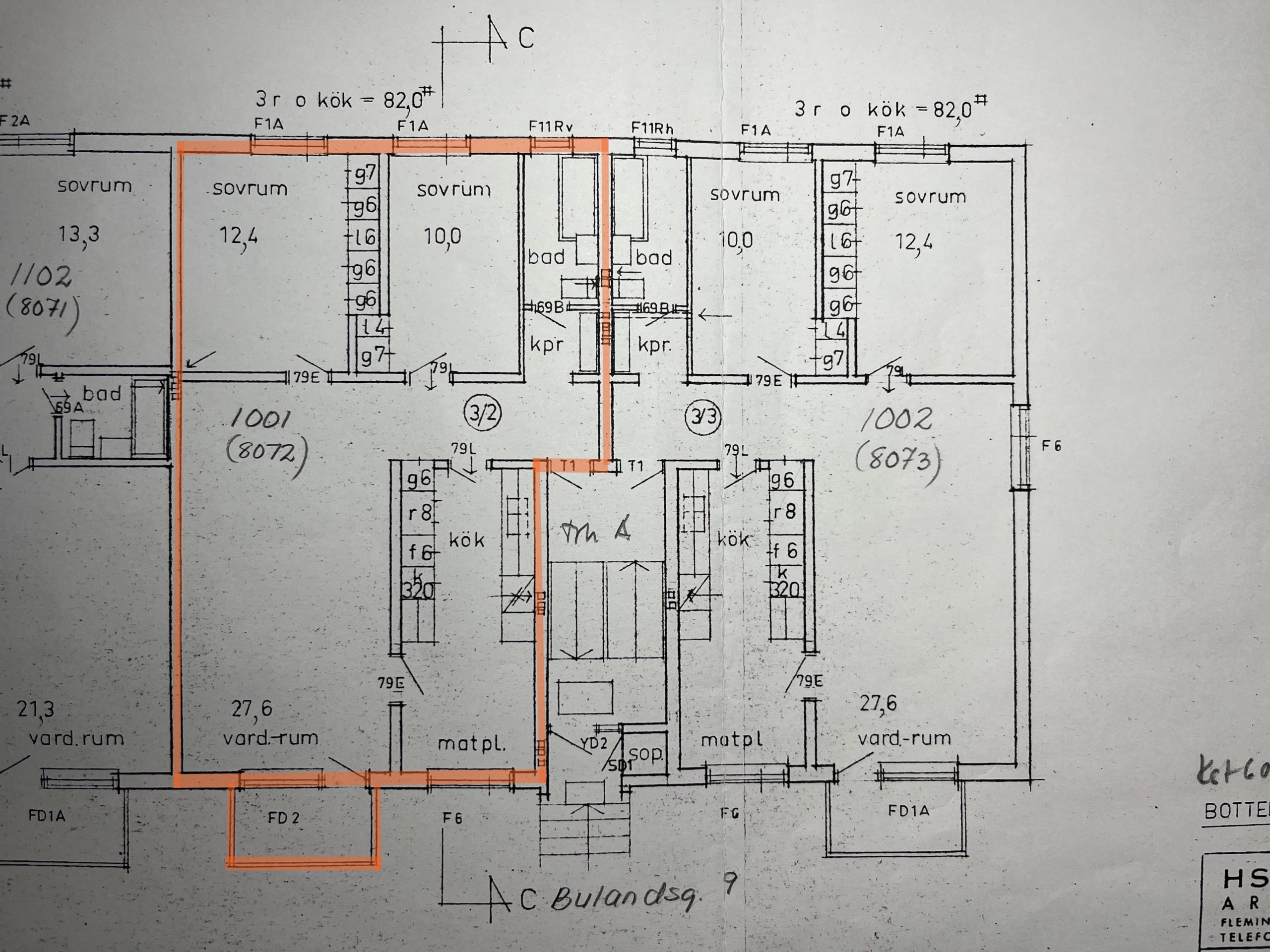 Arkitektonisk planlösning som visar en detaljerad layout av rum inklusive sovrum, vardagsrum och badrum. Olika mått och etiketter anger mått och rumsfunktioner. En orange kontur framhäver vissa delar av planen.