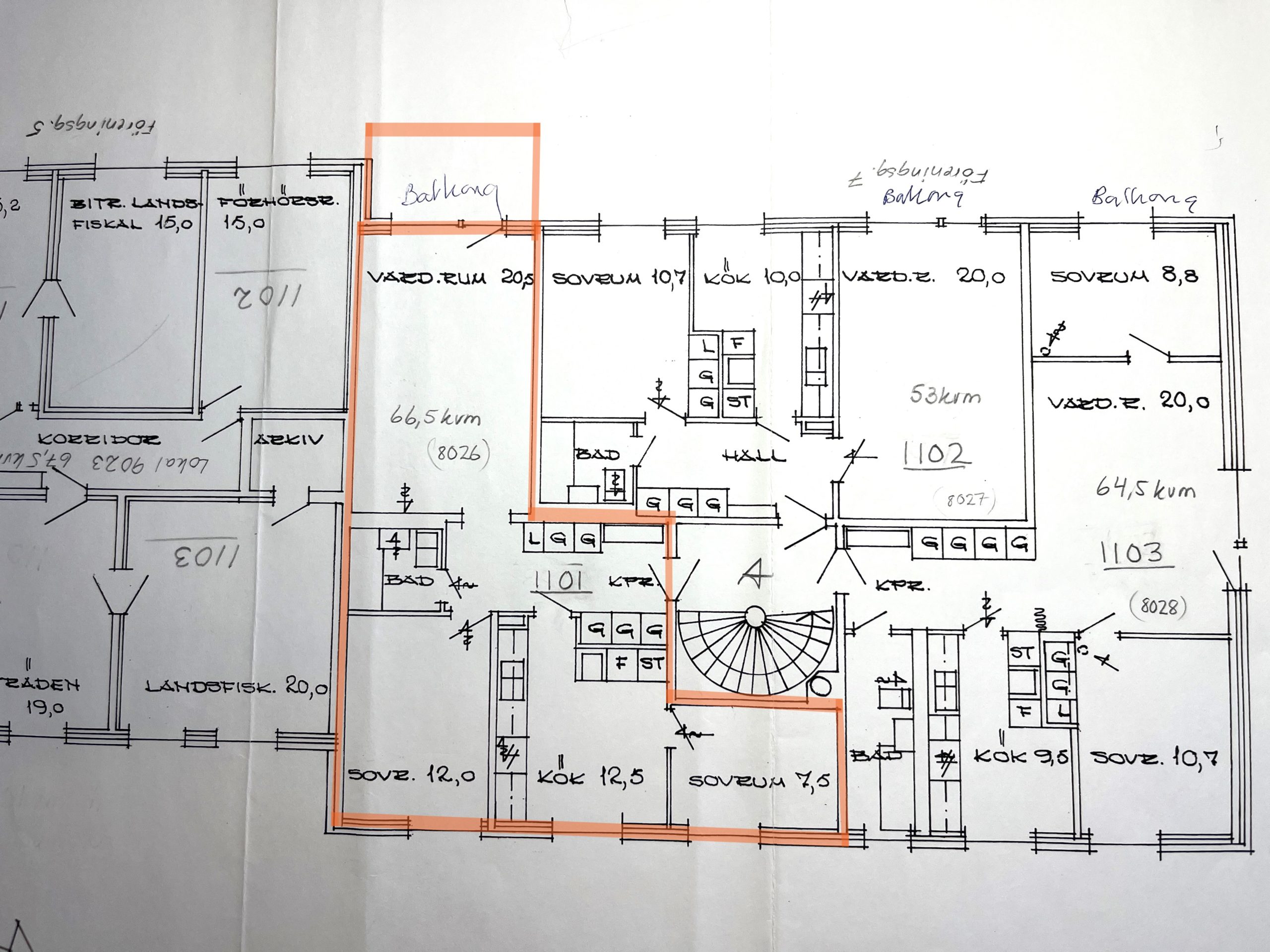 Handritad planlösning för ett flerfamiljshus med flera markerade rum och mått. En central lägenhet är markerad med orange markering, vilket markerar dess rum och planlösning. Handskrivna anteckningar och siffror syns.