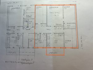 Planlösning för ett flerfamiljshus med flera markerade rum och mått. En större lägenhet är markerad med orange markering, vilket markerar dess rum och planlösning.