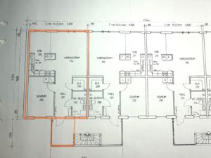 Planlösning för ett flerfamiljshus med flera markerade rum och mått. En lägenhet är markerad med orange markering, vilket markerar dess rum och planlösning.