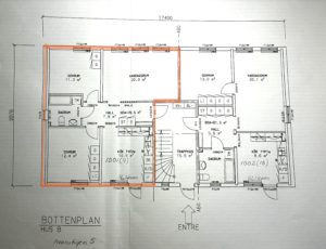 Planlösning för ett flerfamiljshus med flera markerade rum och mått. En lägenhet är markerad med orange markering, vilket markerar dess rum och planlösning.