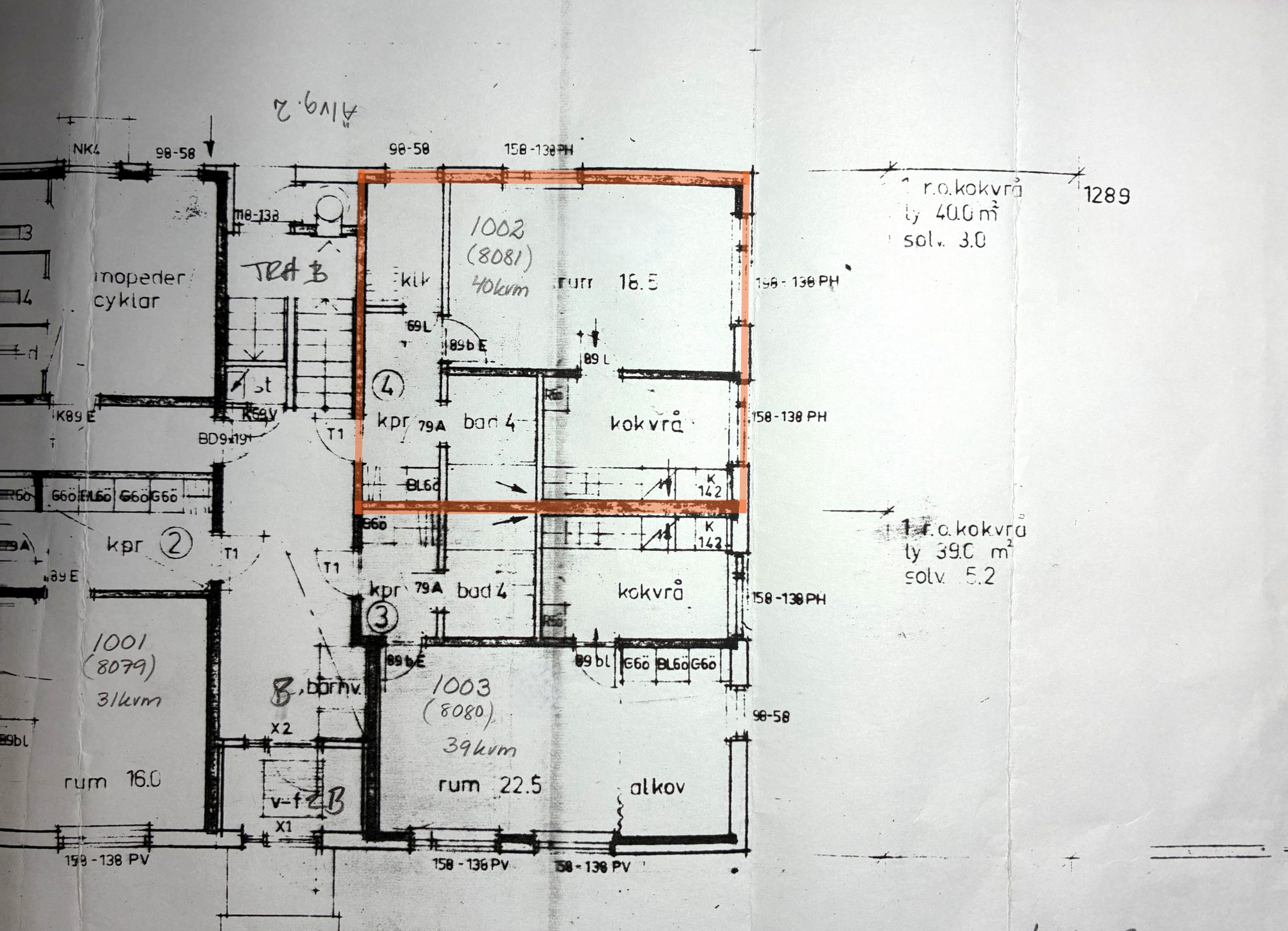 Planlösning för ett flerfamiljshus med flera markerade rum och mått. En lägenhet är markerad med orange markering, vilket markerar dess rum och planlösning.