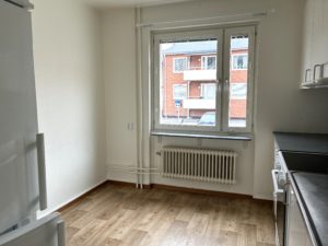 Matplats i köket. Köksinredning och en spis skymtar i förgrunden. Vita väggar och ett fönster på vägggen längst bort.