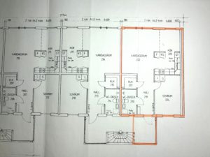 Planlösning för ett flerfamiljshus med flera markerade rum och mått. En lägenhet är markerad med orange markering, vilket markerar dess rum och planlösning.