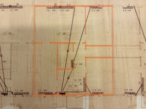 Planlösning för ett flerfamiljshus med flera markerade rum och mått. En central lägenhet är markerad med orange markering, vilket markerar dess rum och planlösning.