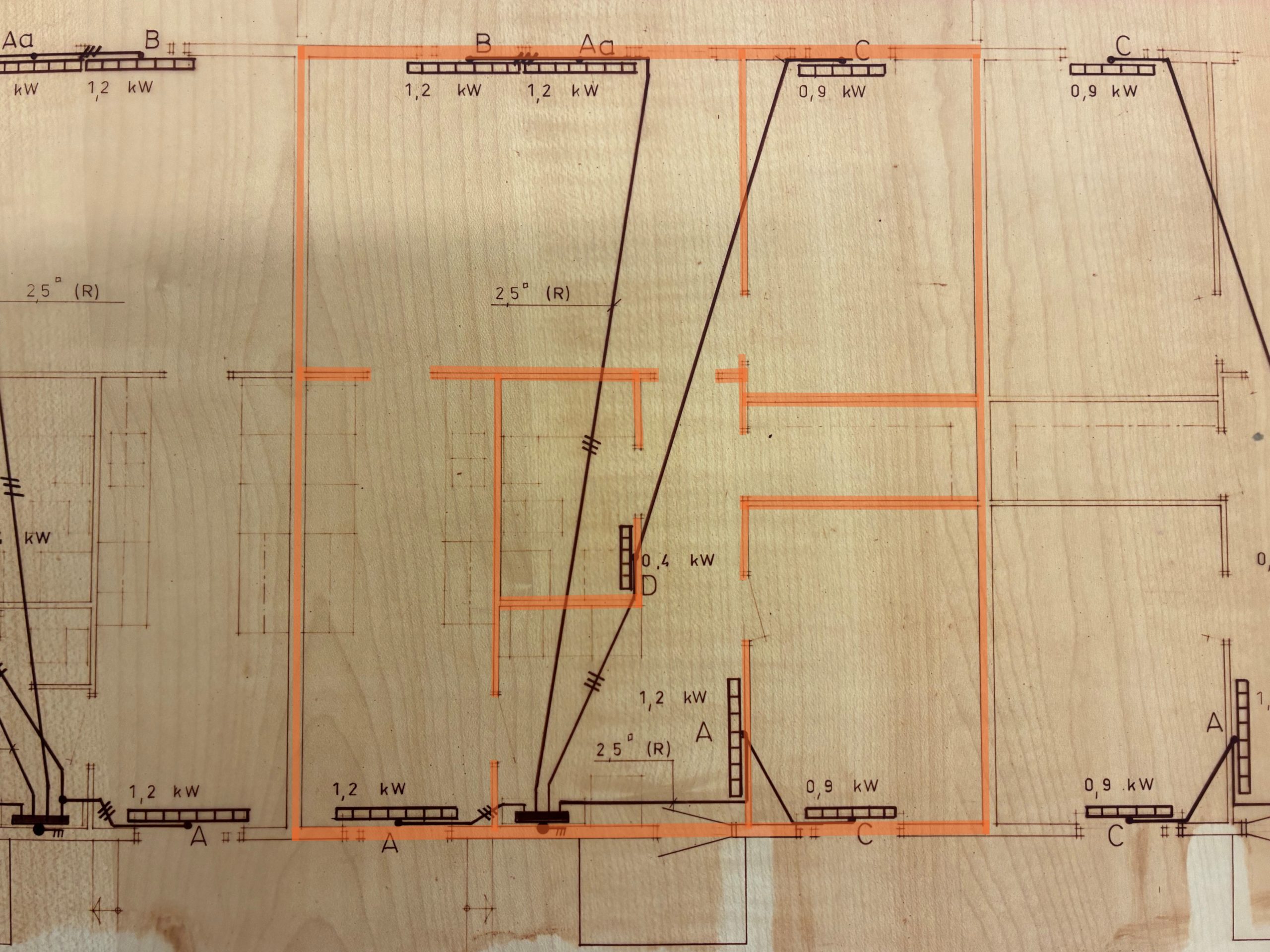 Planlösning för ett flerfamiljshus med flera markerade rum och mått. En central lägenhet är markerad med orange markering, vilket markerar dess rum och planlösning.
