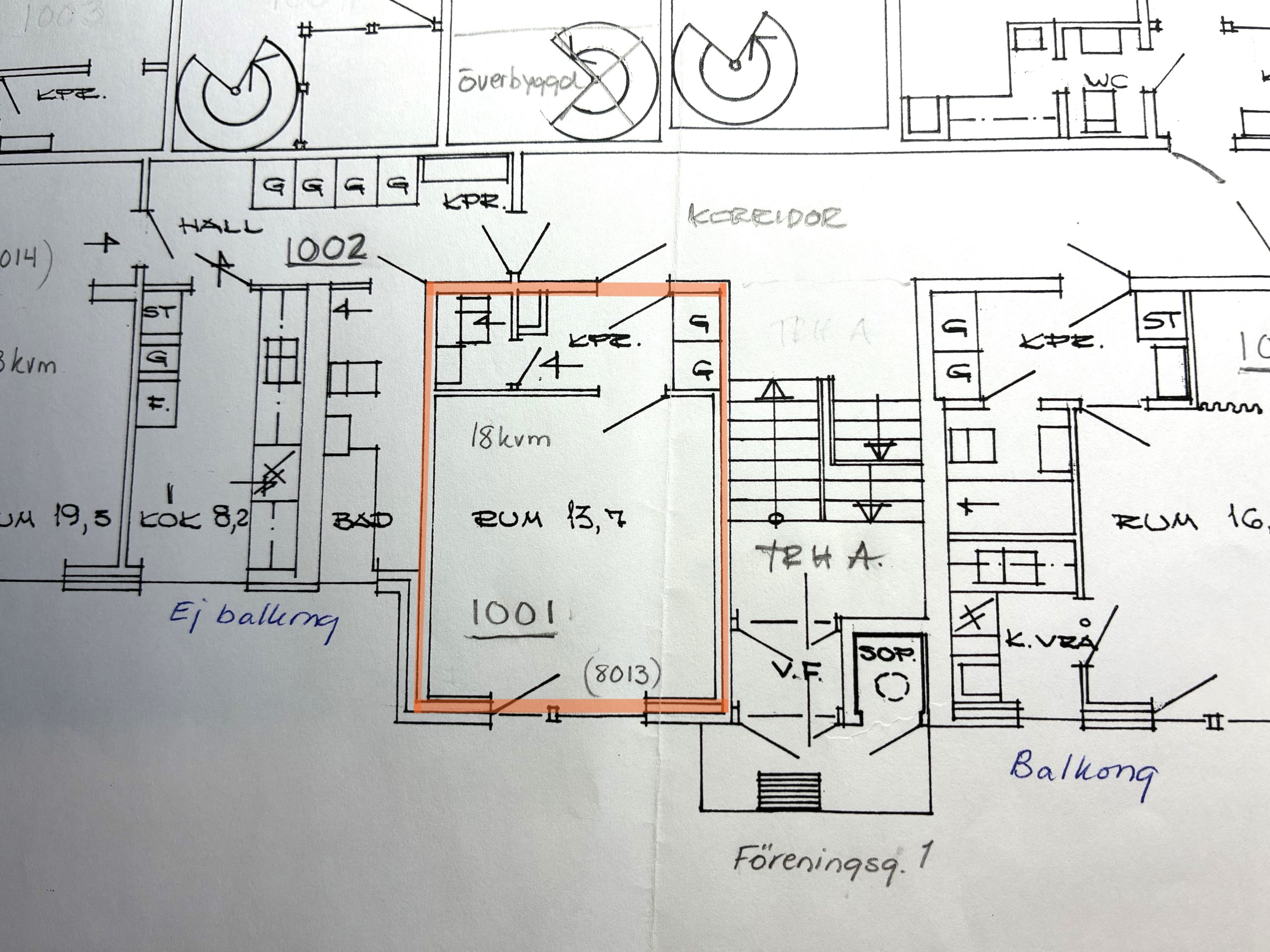 Planlösning för ett flerfamiljshus med flera markerade rum och mått. En mindre lägenhet är markerad med orange markering, vilket markerar dess rum och planlösning.